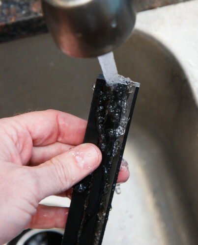 rinsing the rails as part of assembly of the Innovative Marine SafeScreen DIY kit